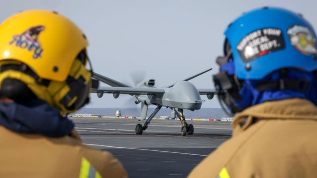 <p>Royal Navy sailors watch as the Mojave unmanned aircraft lands on HMS Prince Of Wales for the first time in history</p>