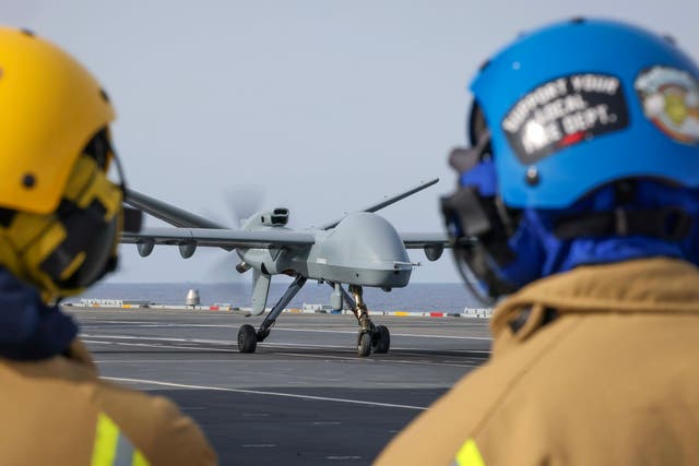 <p>Royal Navy sailors watch as the Mojave unmanned aircraft lands on HMS Prince Of Wales for the first time in history</p>