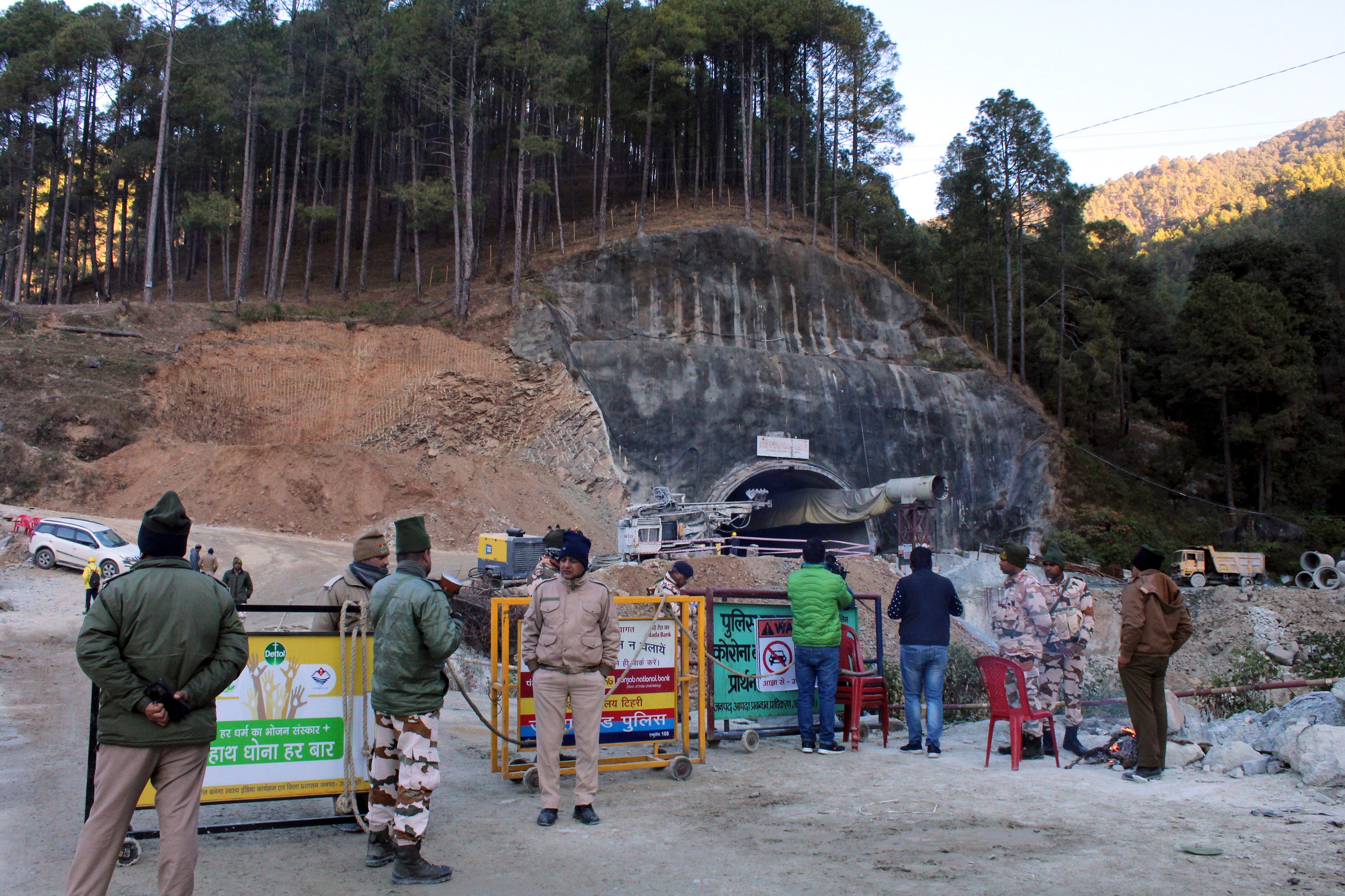 Security officers stand near the entrance to the site of an under-construction road tunnel that collapsed in mountainous Uttarakhand state.