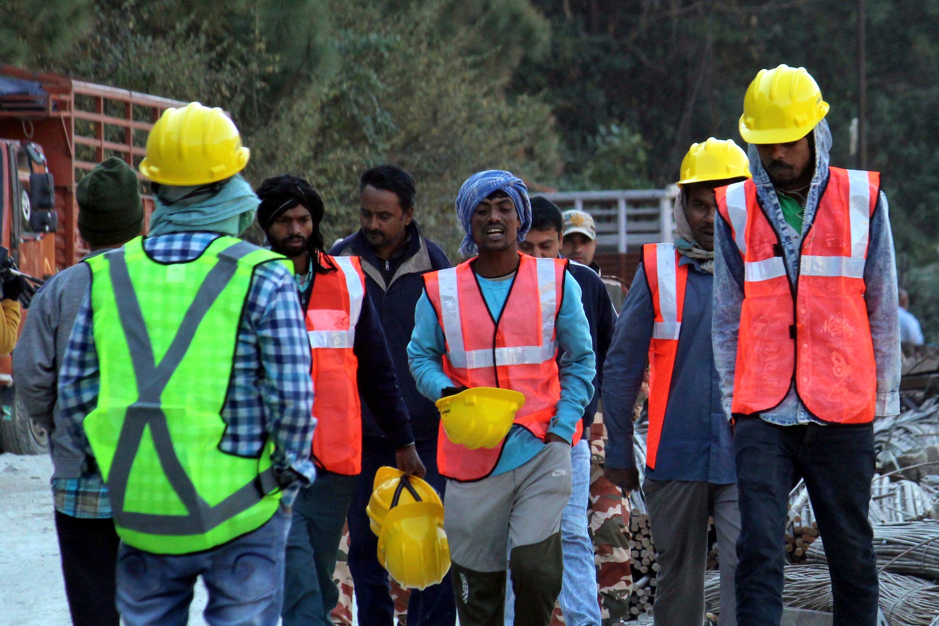 Rescuers walk near the site of an under-construction road tunnel that collapsed in mountainous Uttarakhand state.
