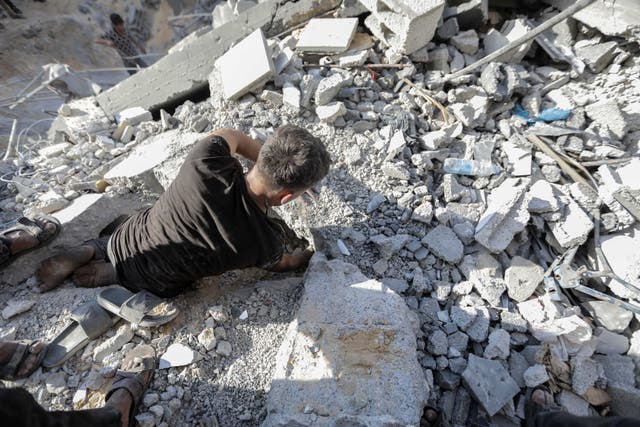 <p>People search buildings destroyed during airstrikes on November 18, 2023 in Khan Yunis, Gaza</p>
