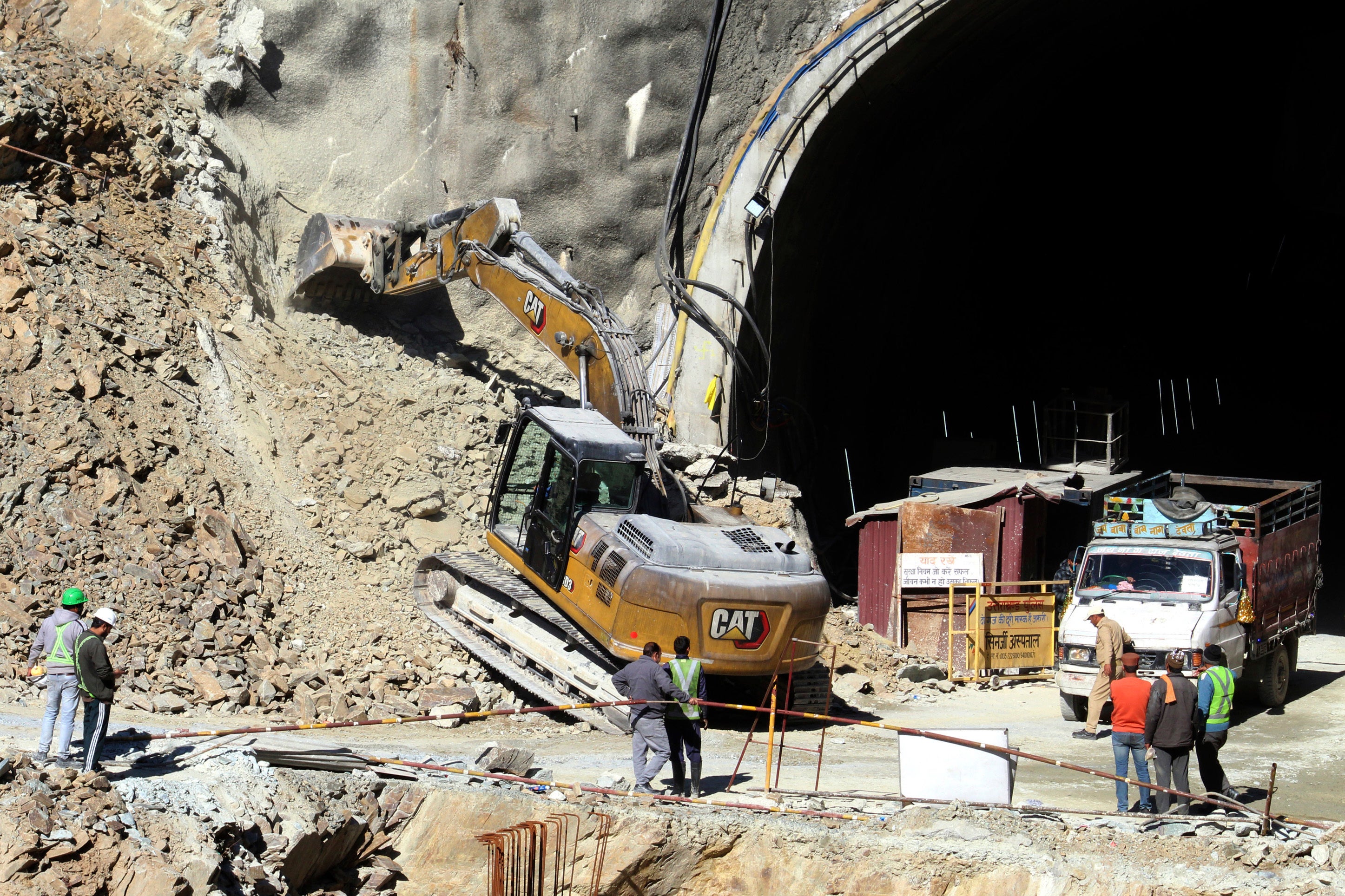 A heavy machinery works at the the entrance to the site of an under-construction road tunnel that collapsed in mountainous Uttarakhand state, India, Saturday, 18 Nov 2023.