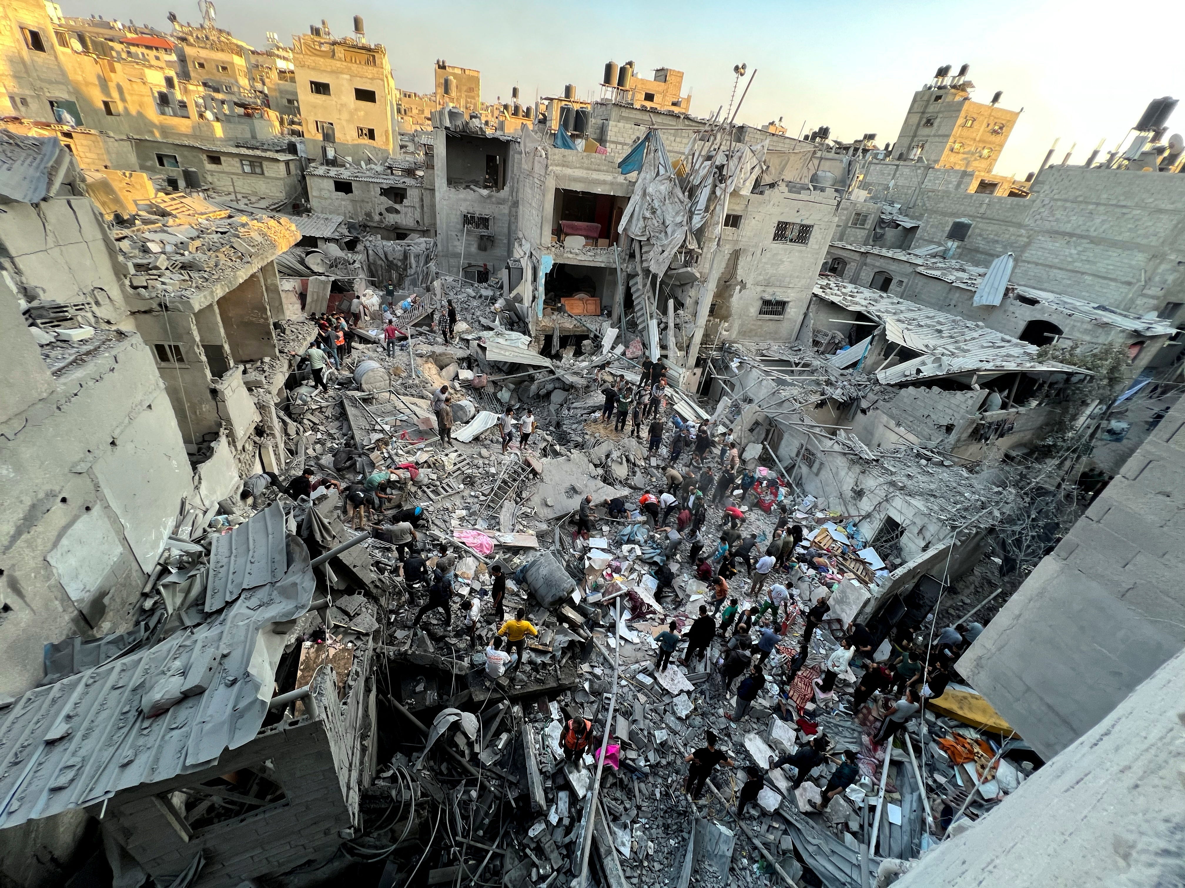 Palestinians search for casualties at the site of Israeli strikes on houses in Jabliya