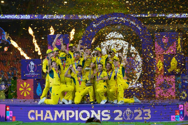 Australia players celebrate with the trophy after winning the World Cup final (Aijaz Rahi/AP)