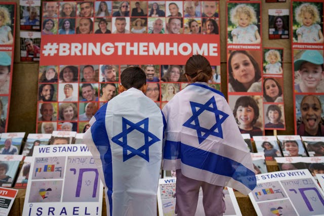 <p>Children in Bucharest look at photographs of Israelis kidnapped by Hamas during a rally joined by hundreds in solidarity with Israel and those held hostage in Gaza</p>
