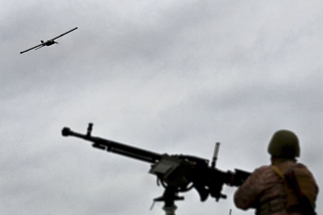 <p>A Ukrainian serviceman stands behind a machine gun as a drone flies during an anti drone drill in Chernigiv region</p>
