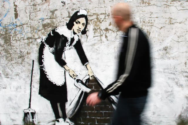 <p>One of Banksy’s most famous outworks, ‘Sweeping It Under The Carpet’, was commissioned by The Independent in 2006</p>