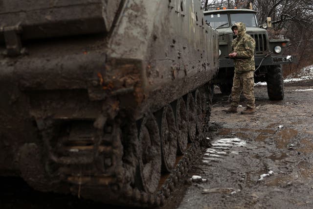 <p>A Ukrainian serciceman prepares a broken armoured personnel carrier (APC) in order to evacuate a road in Donetsk region</p>