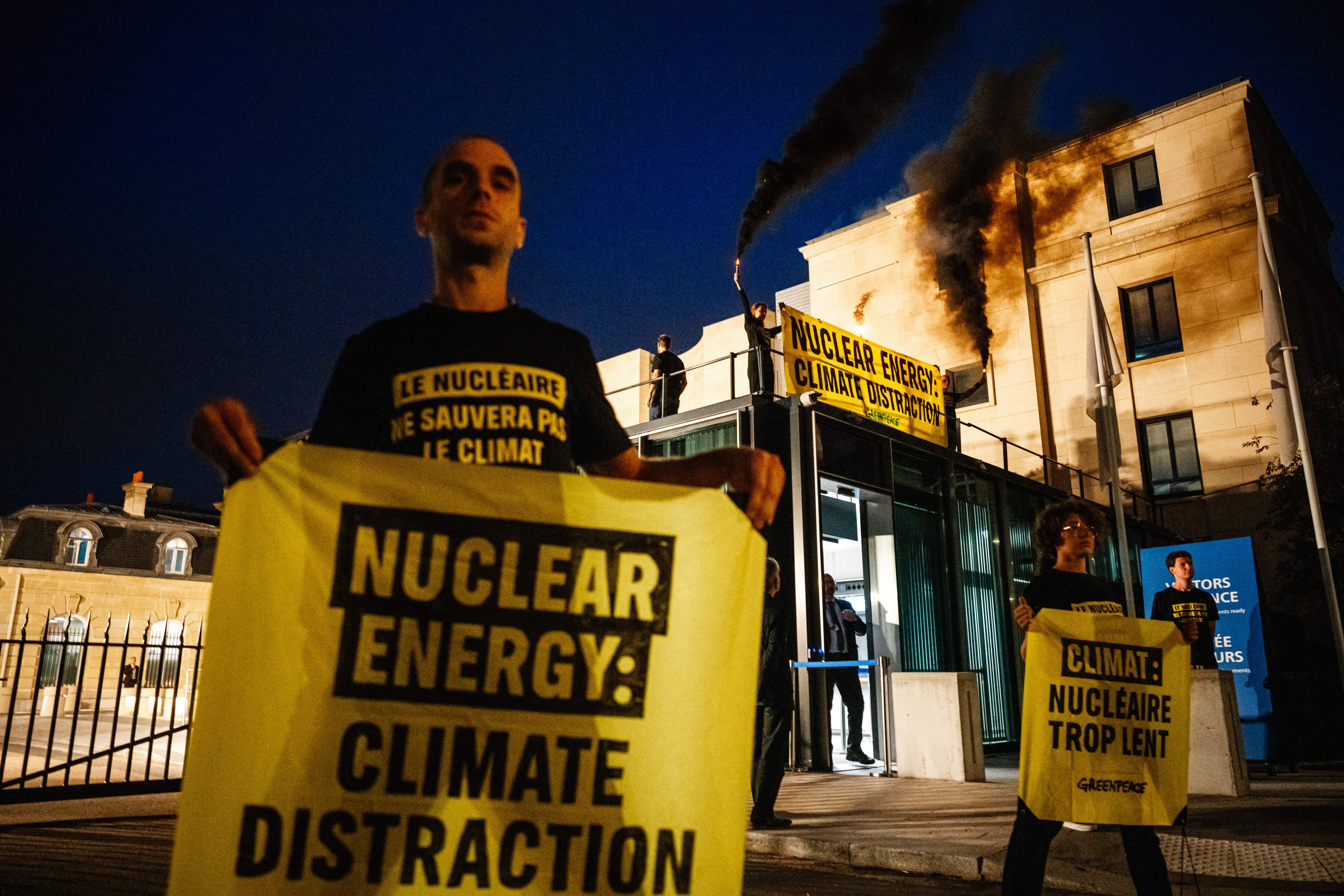 Greenpeace activists light torches and hold anti-nuclear banners prior to the opening of a nuclear energy conference in Germany in September