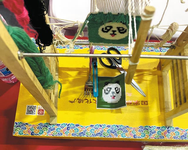 <p>A miniature wooden loom shows the complexity and delicacy of imperial carpet-making at the Beijing International Week of Intangible Cultural Heritage in October 2023</p>