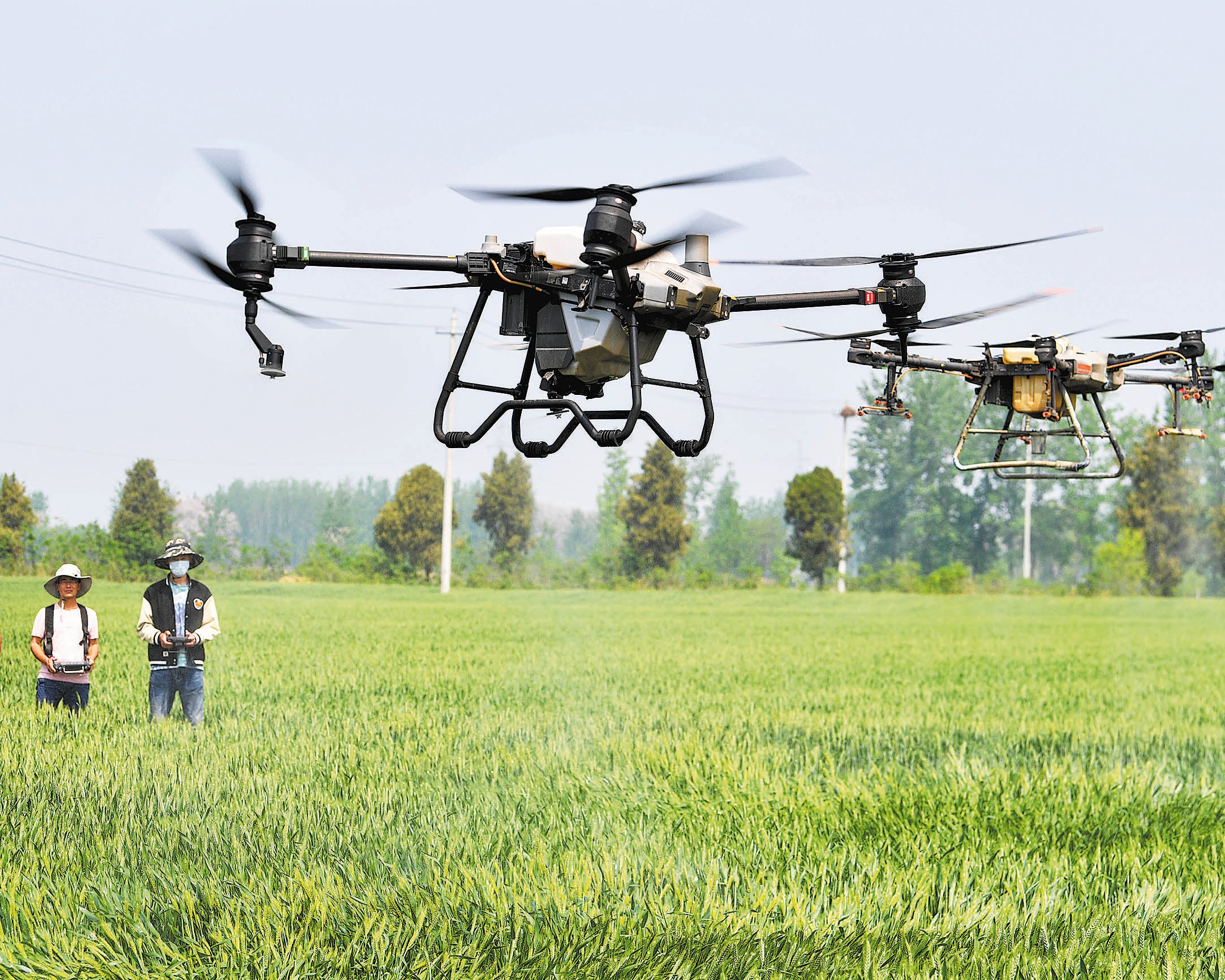 Farmers use farm-specific drones to help spray pesticide in Bozhou, Anhui province, in April 2023