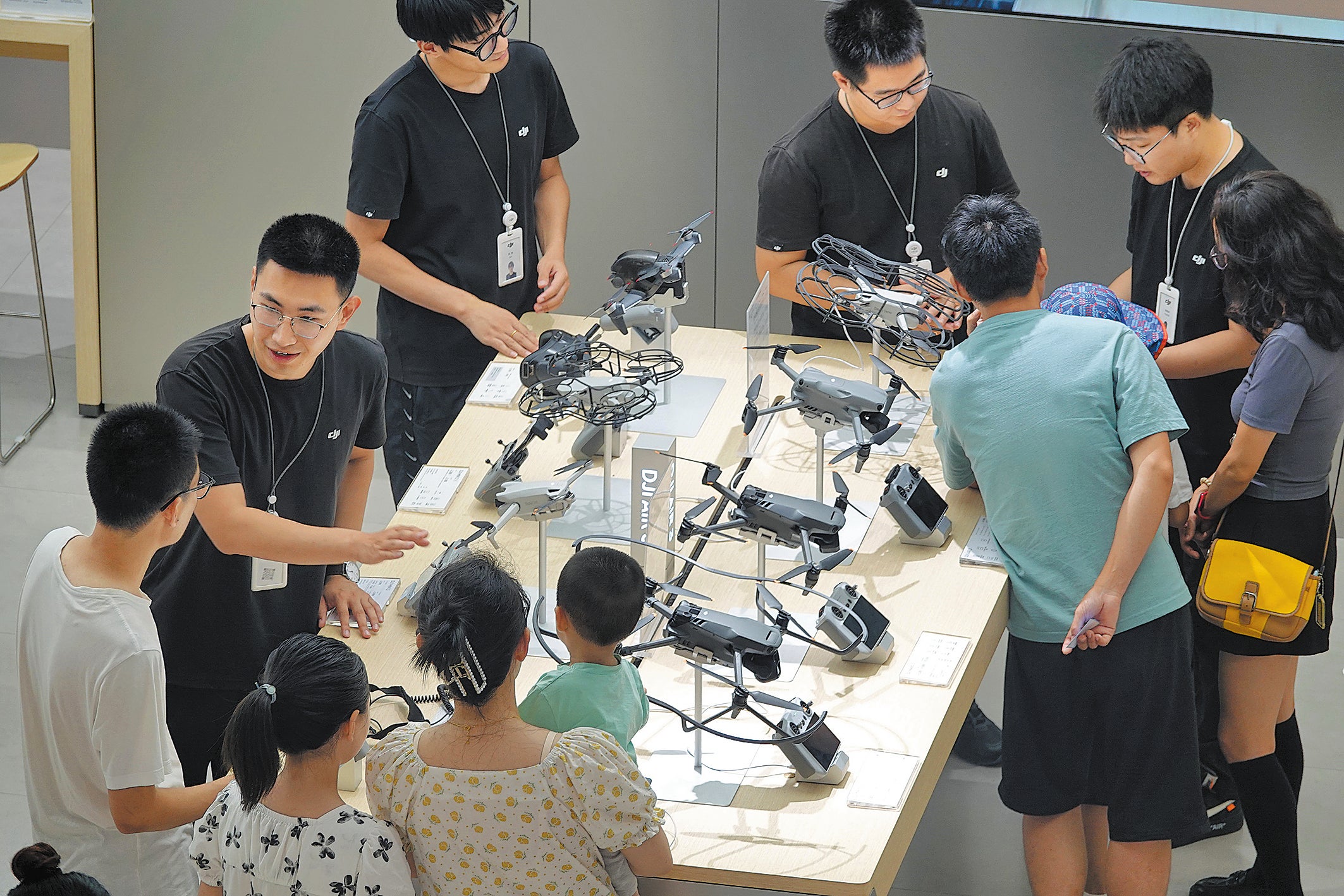 Employees introduce drones to potential buyers at a DJI experience store in Yantai in July 2023