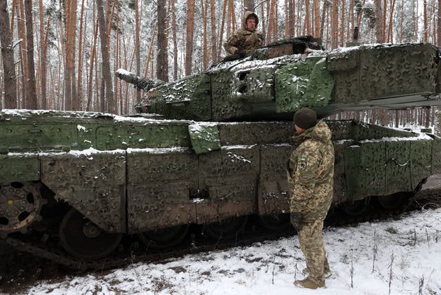 <p>Ukrainian tank crew members of the 21st Mechanized Brigade chat as one stands in the hatch of a German battle tank Leopard 2A5 near the front line in an undisclosed location in the Lyman direction of the Donetsk region</p>