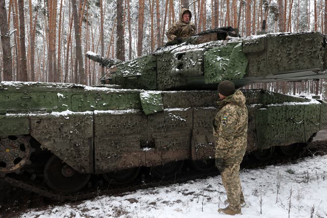 <p>Ukrainian tank crew members of the 21st Mechanized Brigade chat as one stands in the hatch of a German battle tank Leopard 2A5 near the front line in an undisclosed location in the Lyman direction of the Donetsk region</p>