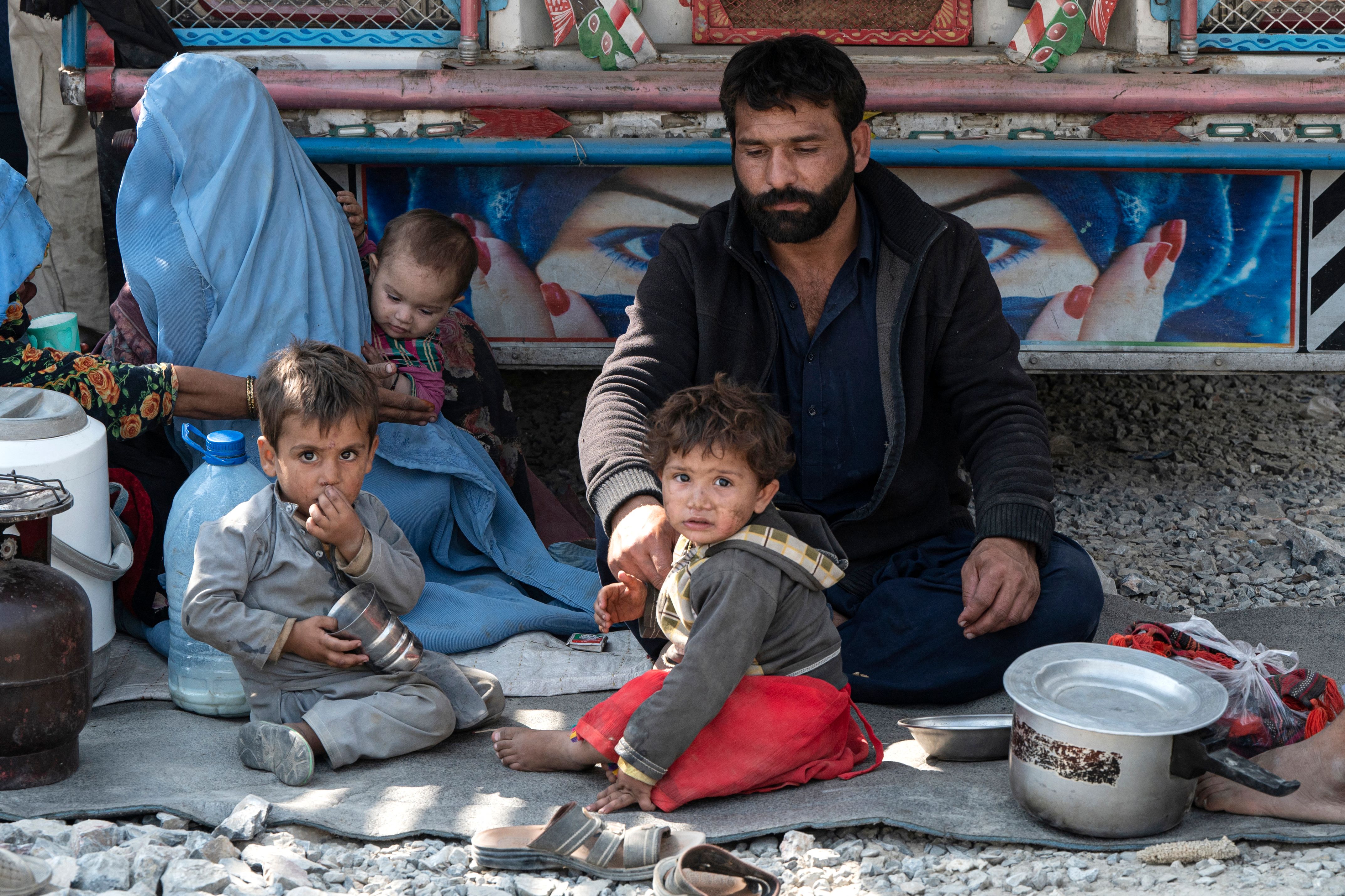 Afghan refugees receive bread from a local charity at a makeshift camp