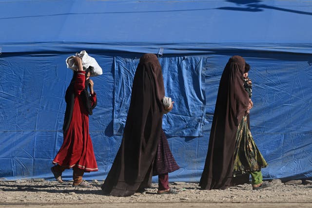 <p>Afghan refugees walk through a makeshift camp upon their arrival from Pakistan, near the Afghanistan-Pakistan Torkham border in Nangarhar province</p>