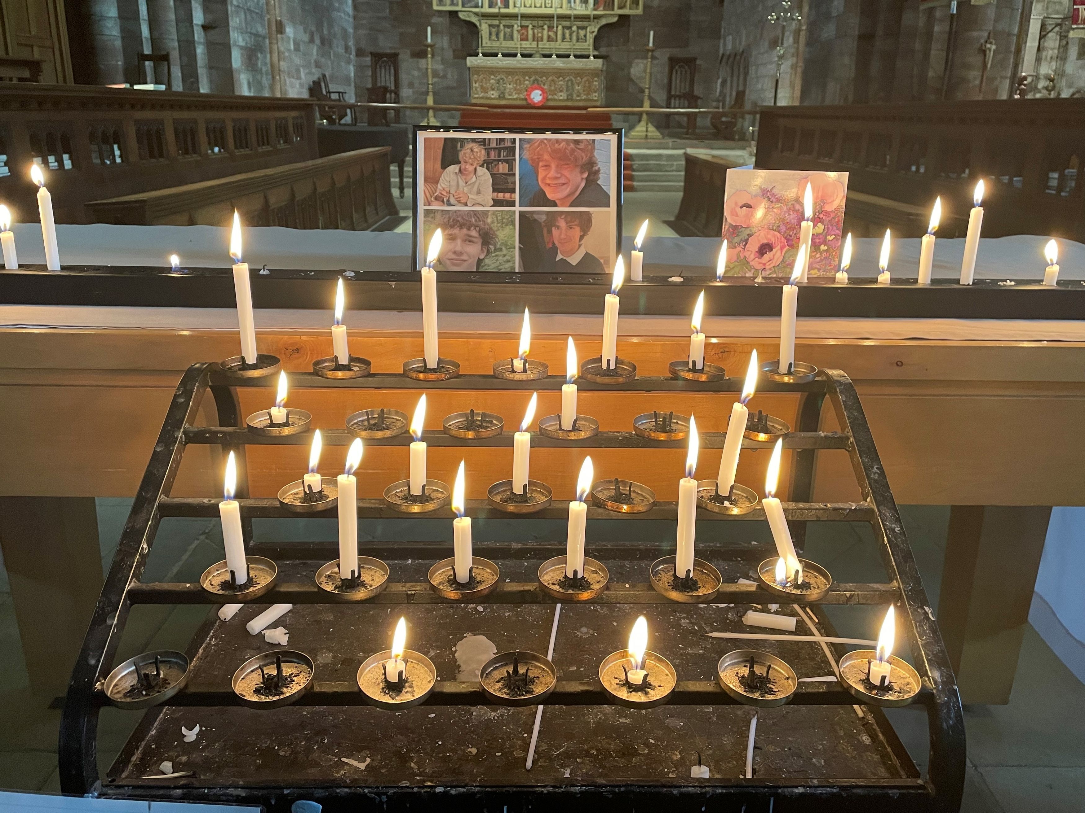 A photo of the four teenagers who died in a car crash in in Snowdonia, North Wales, by candles and a sympathy card inside Shrewsbury Abbey