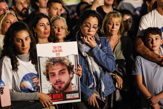 <p>Family and friends with a photo of Alon Ohel, who was taken hostage by Hamas on 7 October 2023</p>