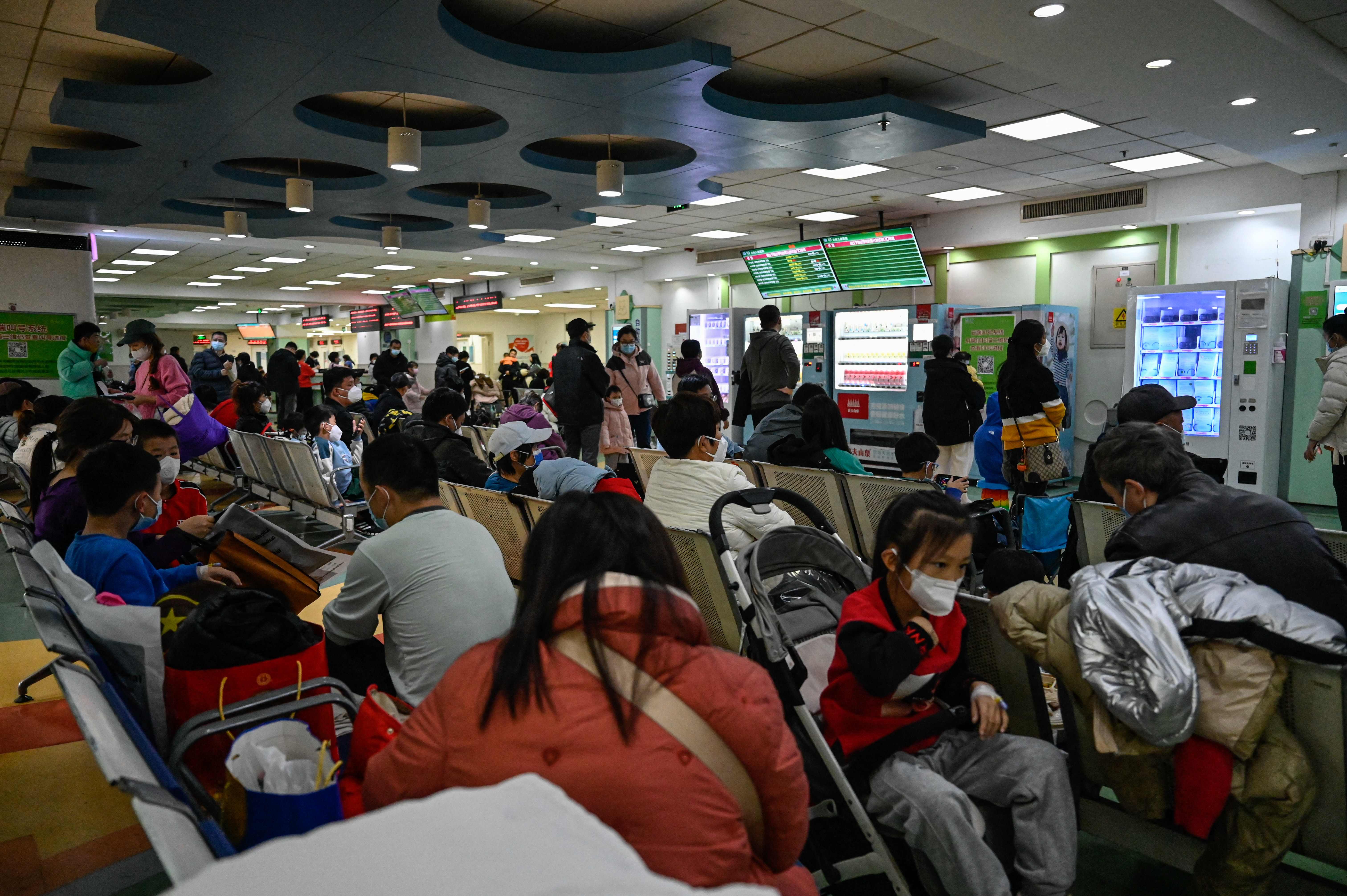 Children and their parents wait at an outpatient area at a children’s hospital in Beijing on 23 November