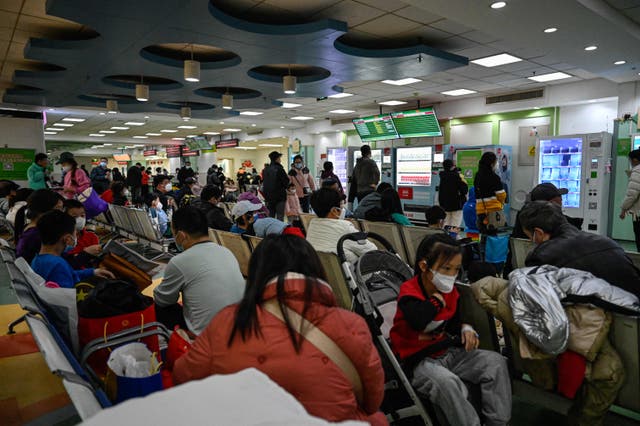 <p>Children and their parents wait at an outpatient area at a children’s hospital in Beijing on 23 November</p>