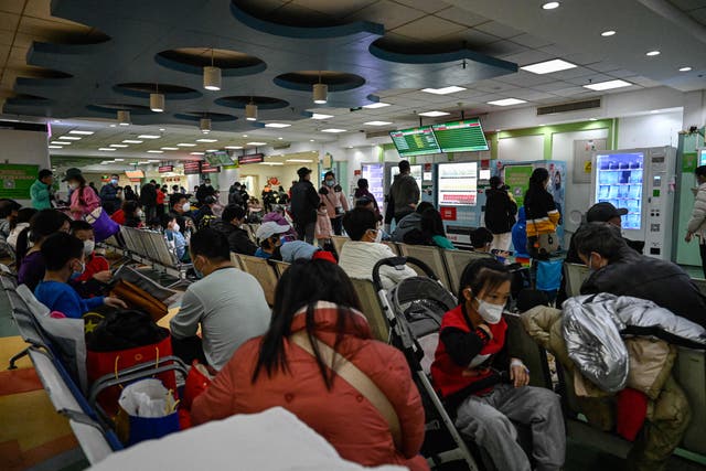 <p>Children and their parents wait at an outpatient area at a children’s hospital in Beijing on 23 November</p>