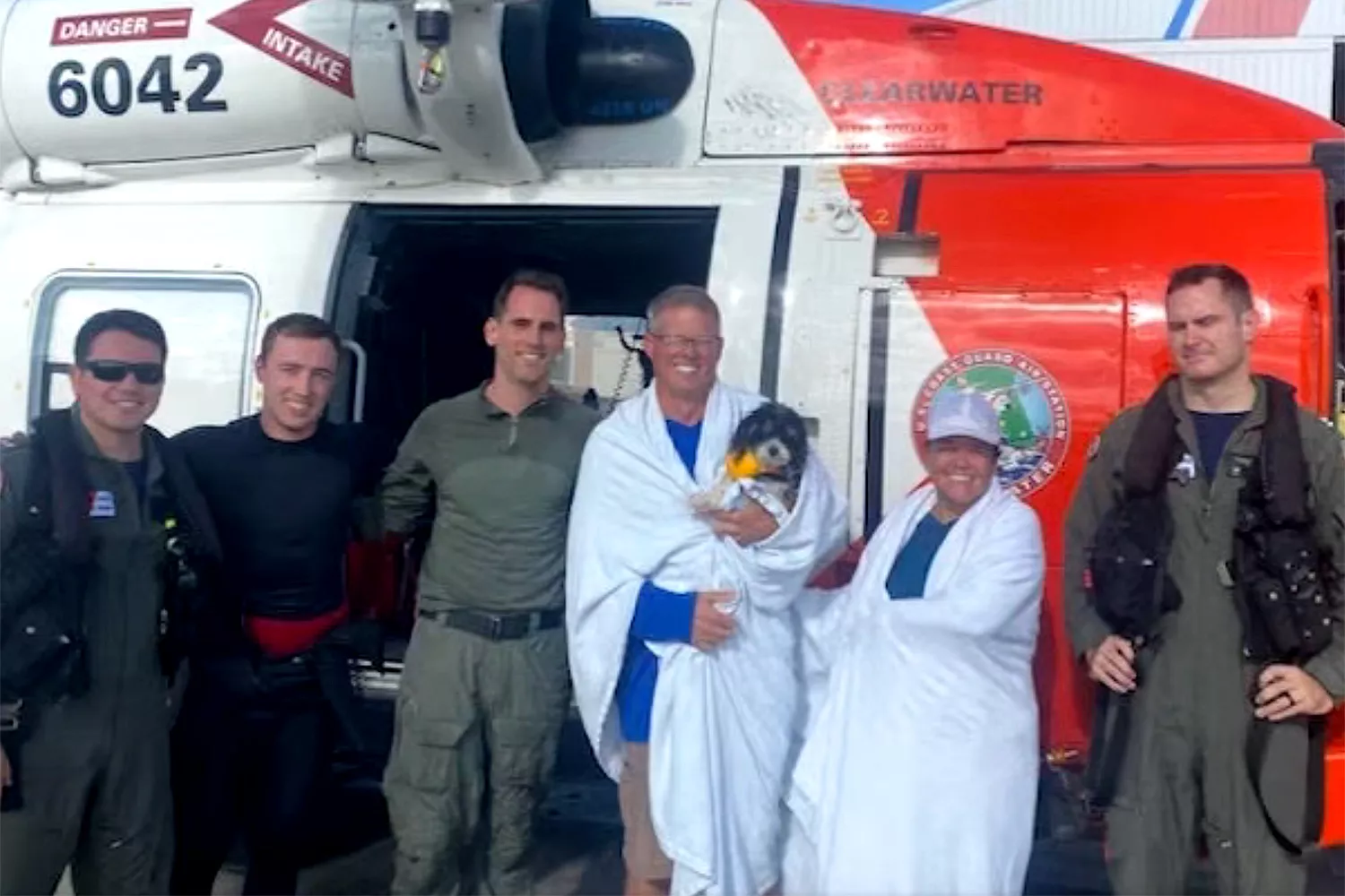 Safe and wrapped up after the couple and their pooch were airlifted to safety