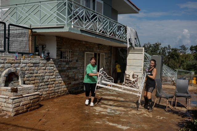 <p>Farmer Christina Gkareli (right) and a family member move a bed frame after Storm Elias flooded her house, in the central Greek village of Sesklo </p>