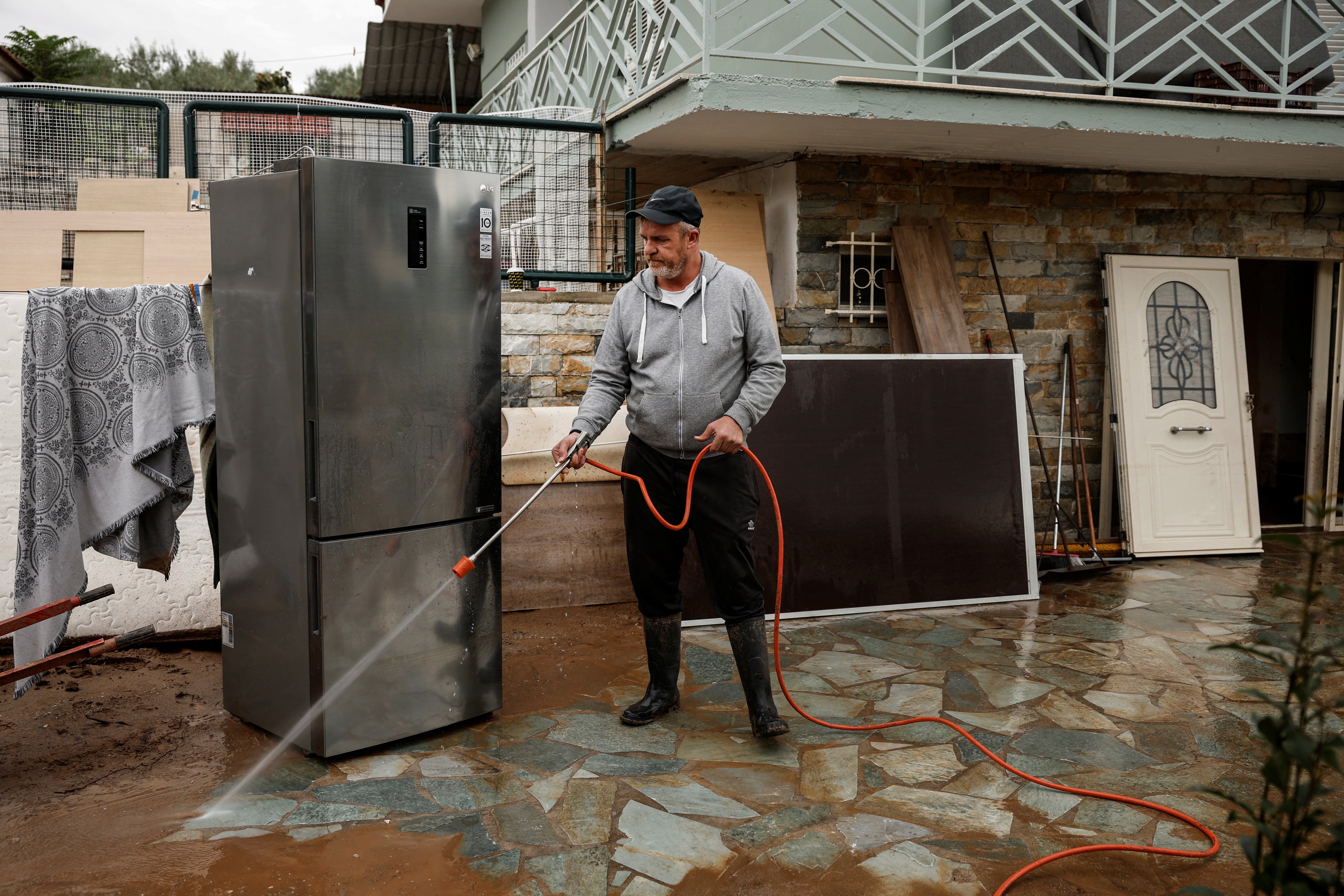 Tsiamitas cleans the yard at his house after the flood