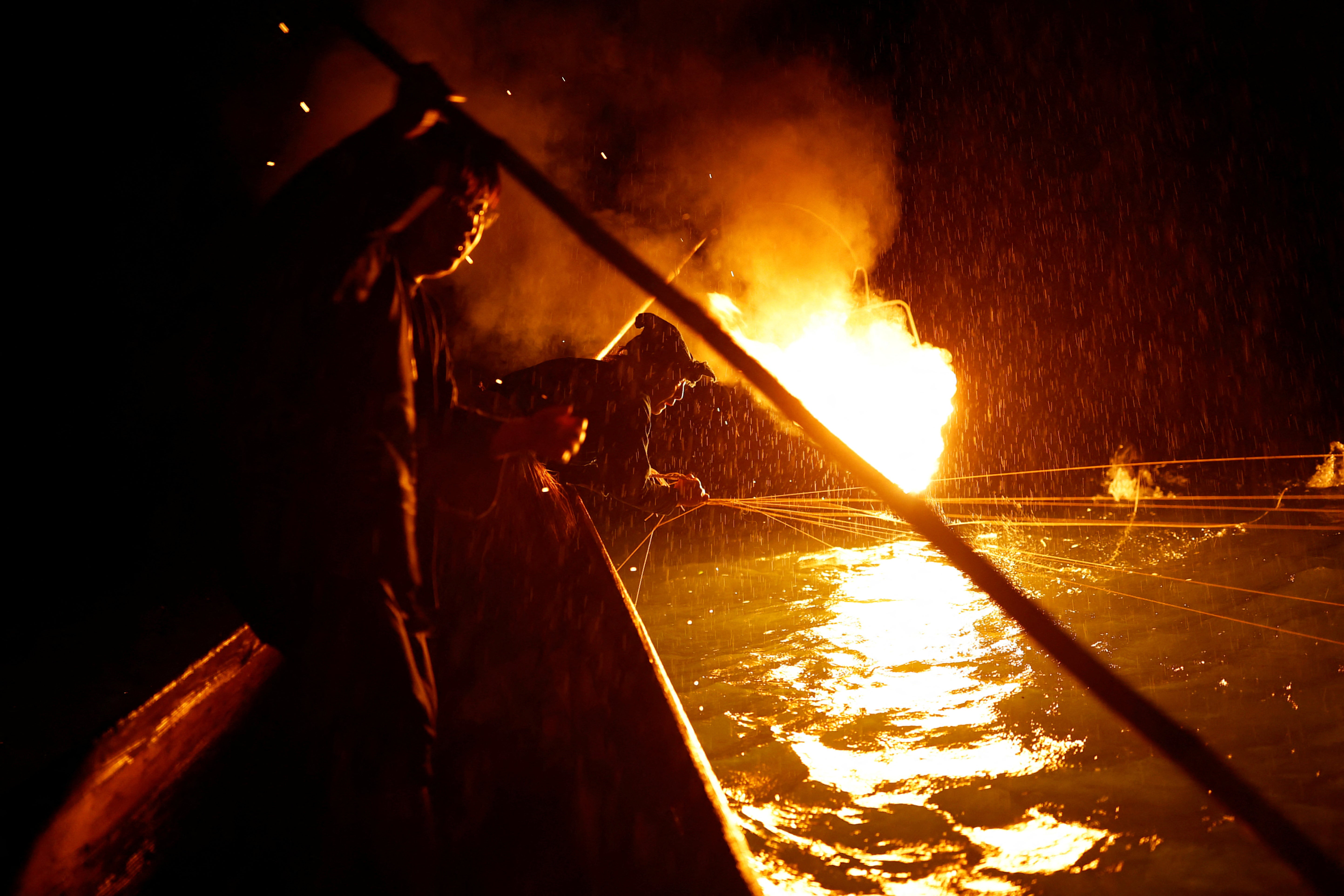 Youichiro Adachi (right), controls leashes tied to the cormorants’ necks and bodies while his son, Toichiro, 22, manoeuvres their boat during fishing