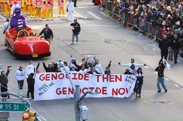 <p>Protestors carrying a ‘Genocide then. Genocide now’ banner </p>