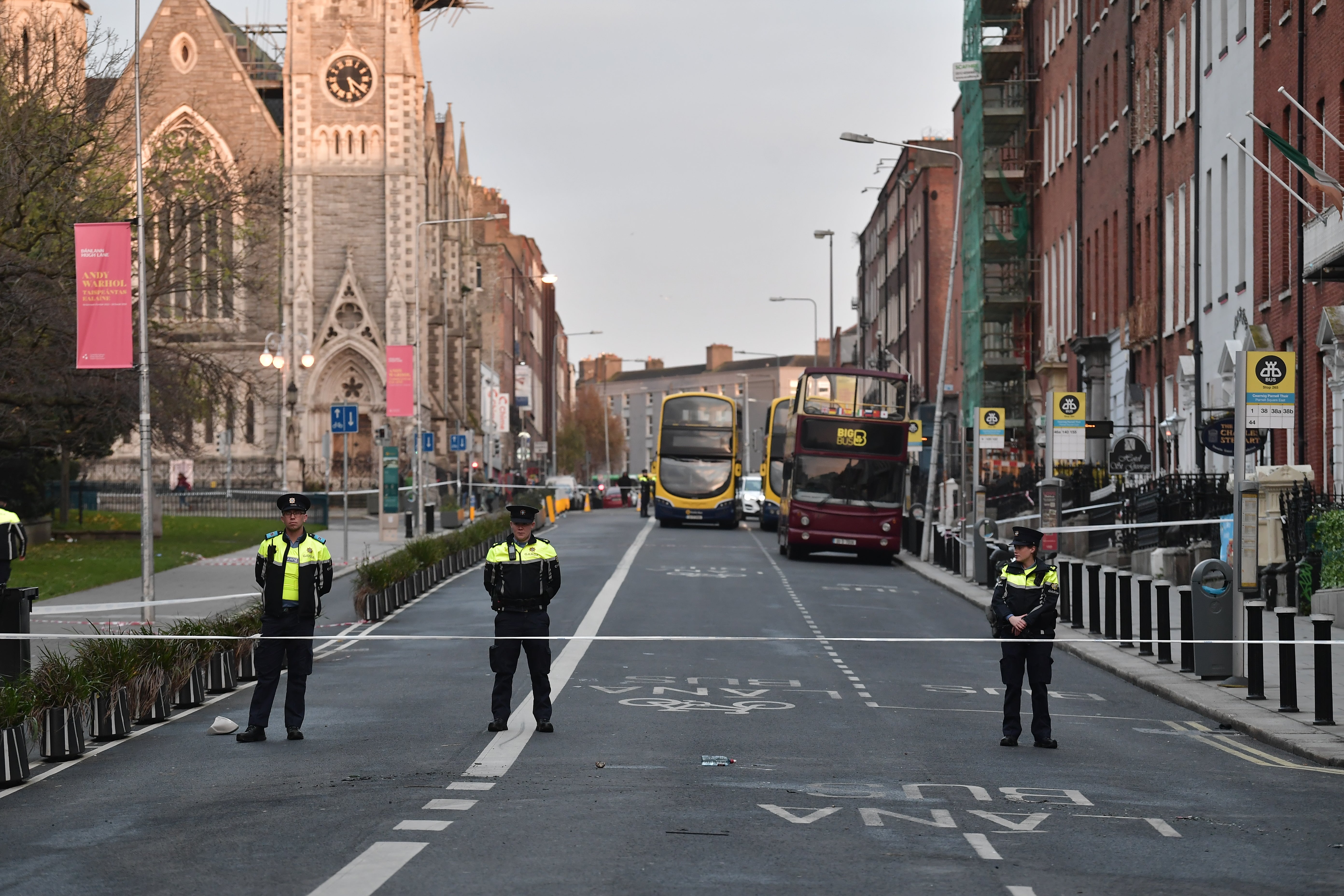 Three police officers stand near the crime scene from Thursday’s stabbing on Friday in Dublin, Ireland