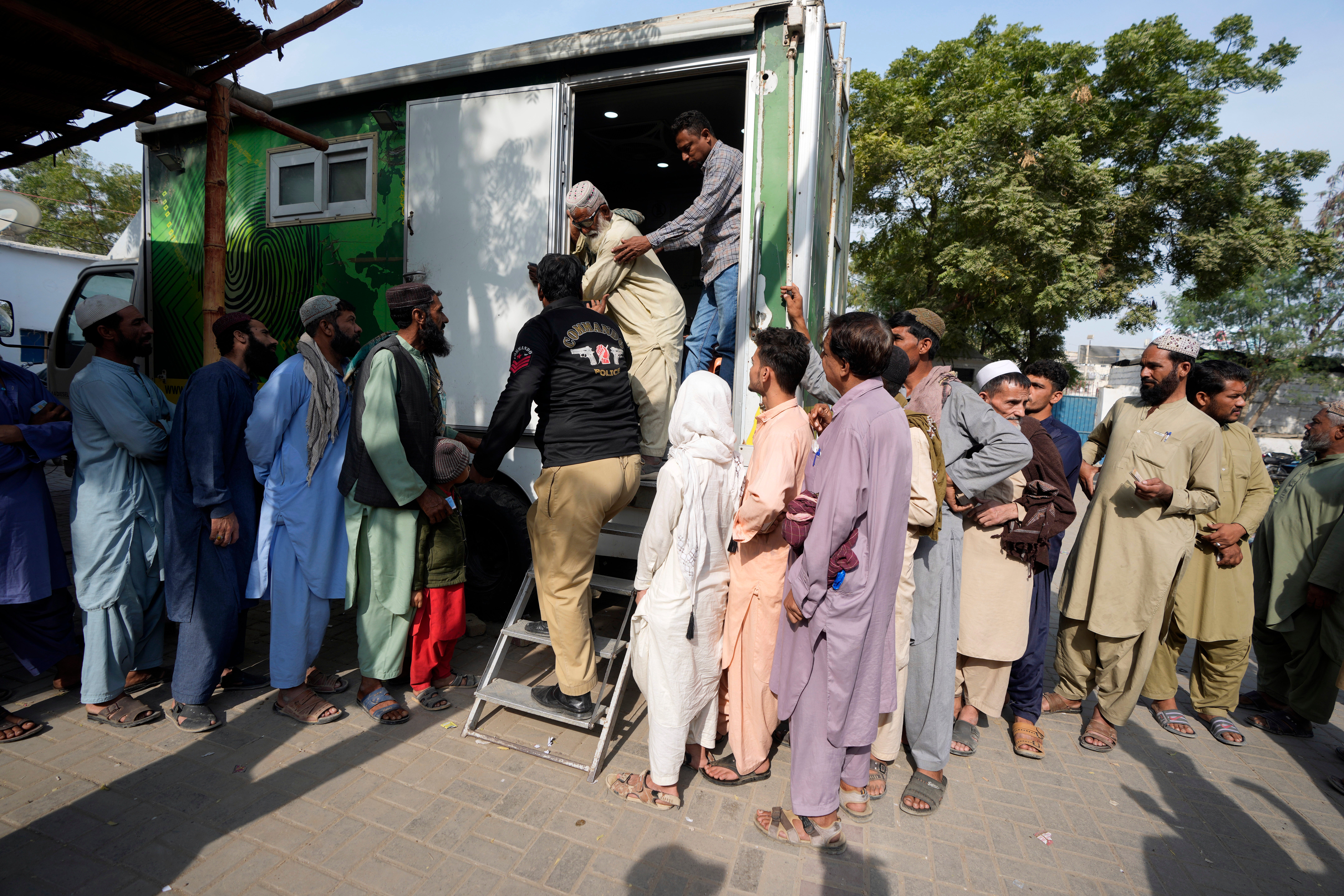 Immigrants, mostly Afghans, line up as they wait for their turn to verify data at a counter of Pakistan’s National Database and Registration Authority in Karachi