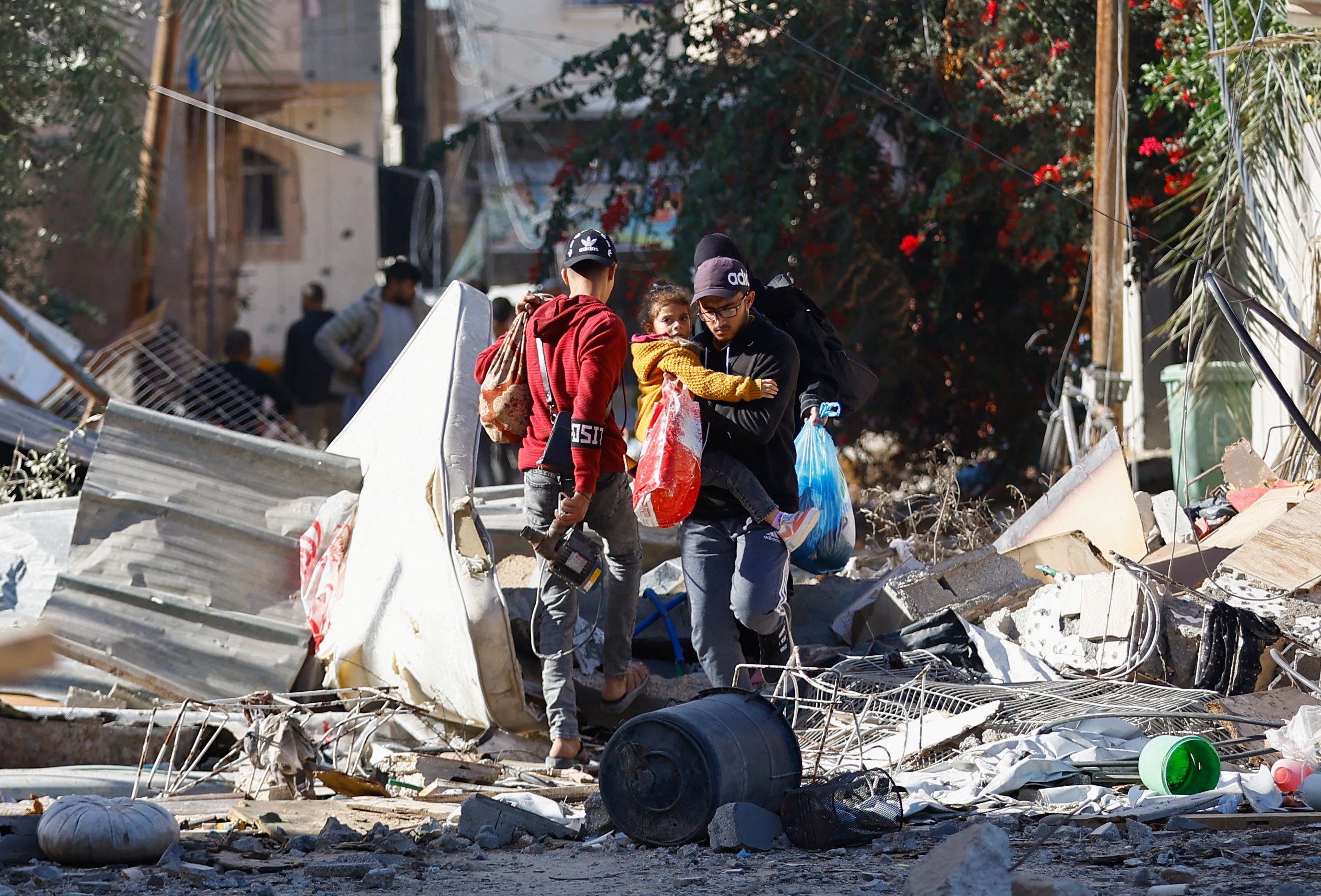 Displaced Palestinians stand among the rubble of houses destroyed in an Israeli strike during the conflict, as they return to their homes,