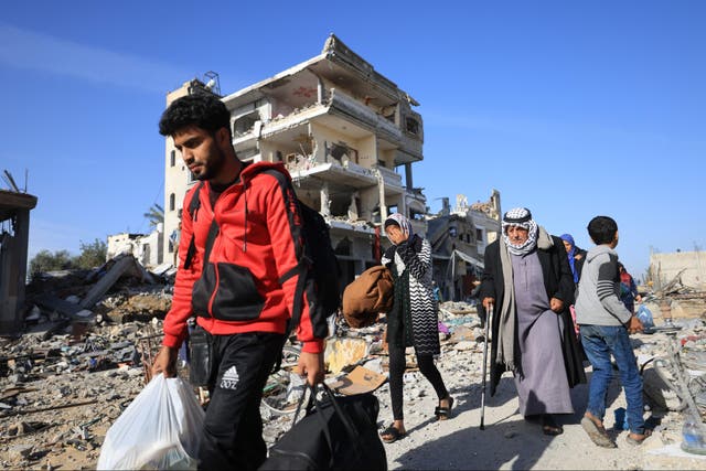 <p> Palestinians walk through debris in southern Gaza</p>