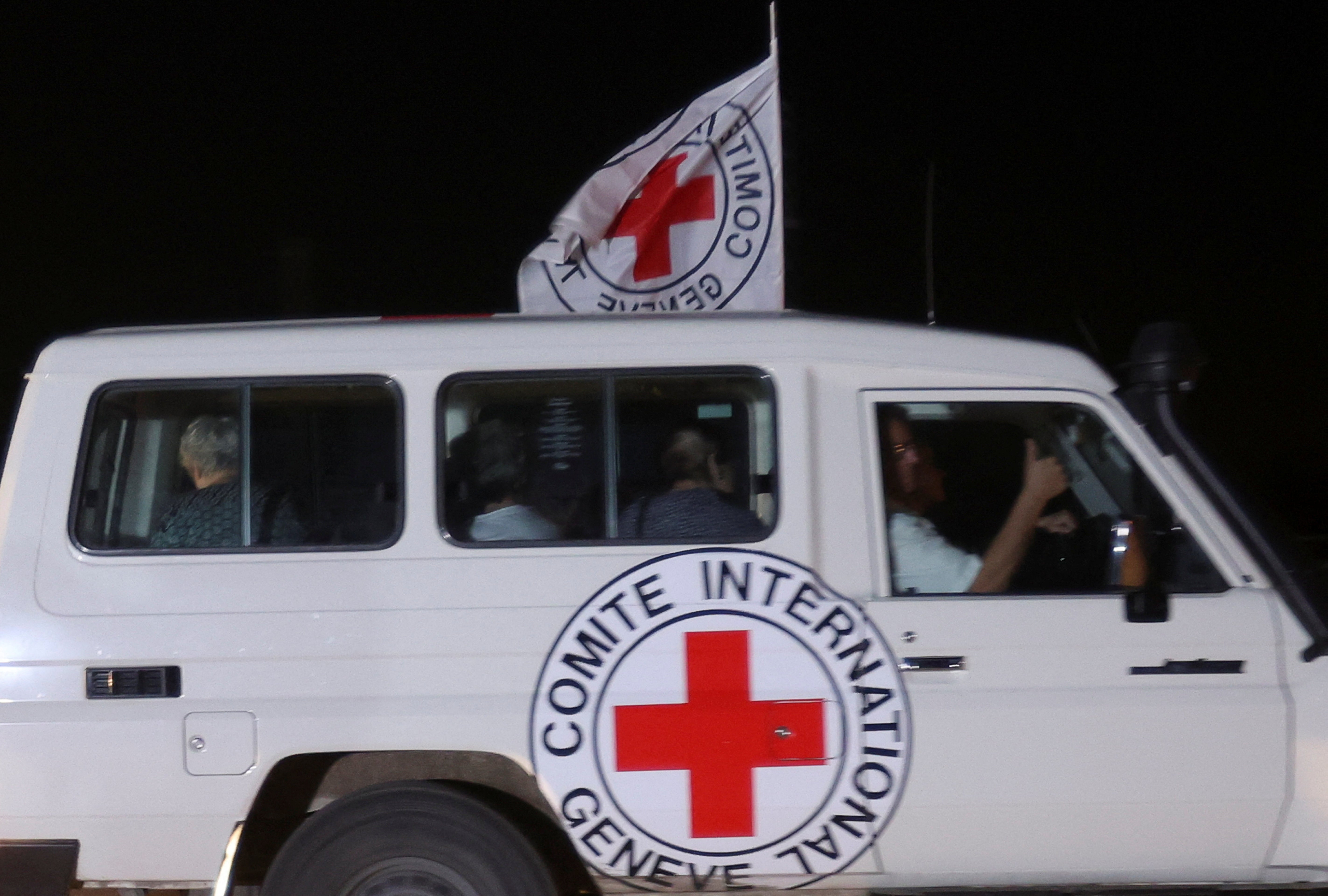 A Red Cross vehicle believed to be carrying hostages abducted by Hamas on 7 October arrives at the Rafah border on Friday