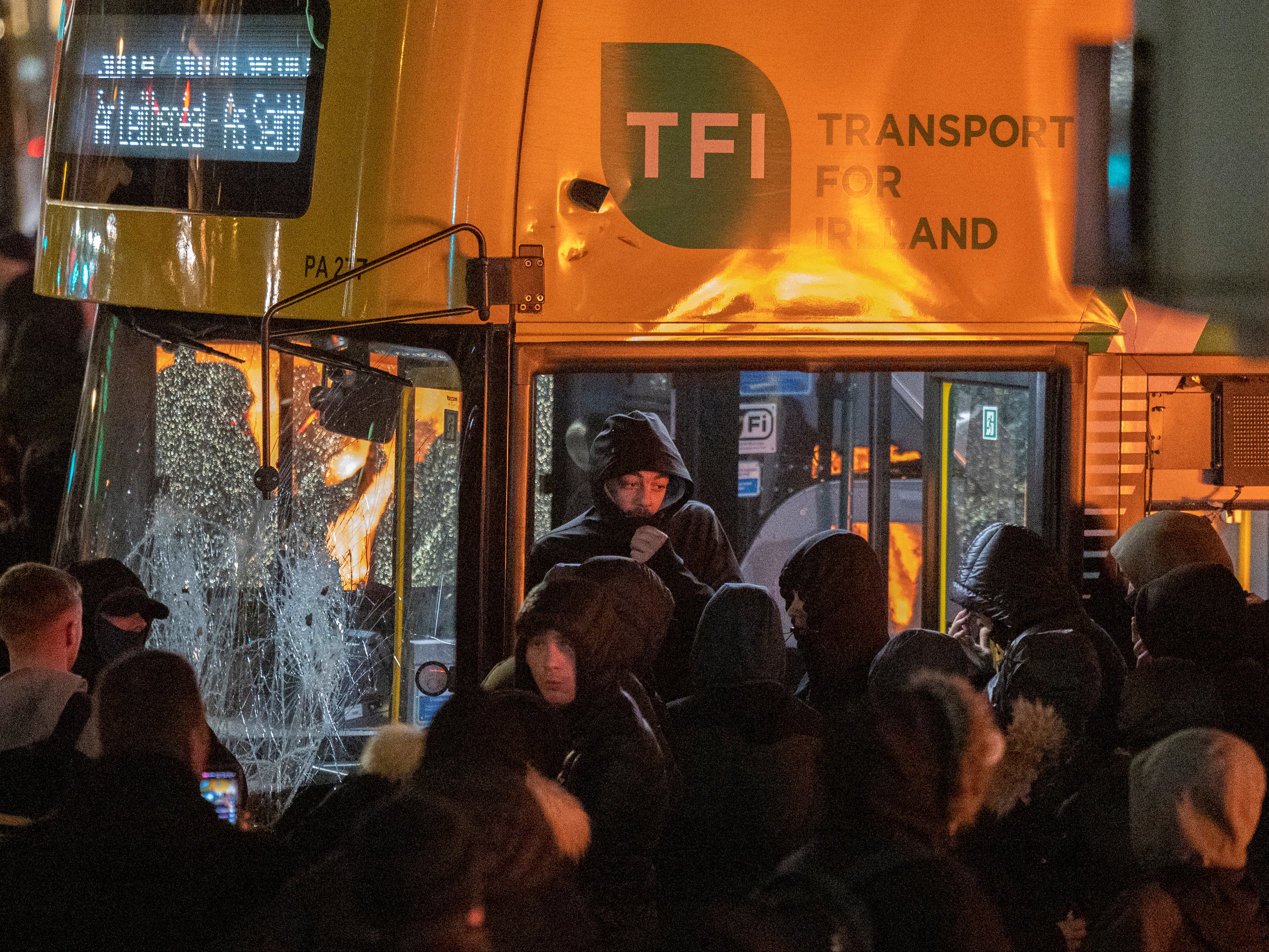 Demonstrators smash a bus with hammers and set it alight on Thursday night