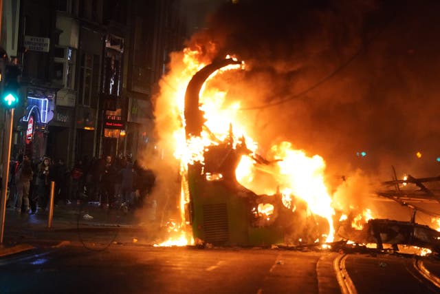 <p>A bus on fire on O’Connell Street in Dublin city centre after violent scenes unfolded following a knife attack on Parnell Square East on Thursday</p>