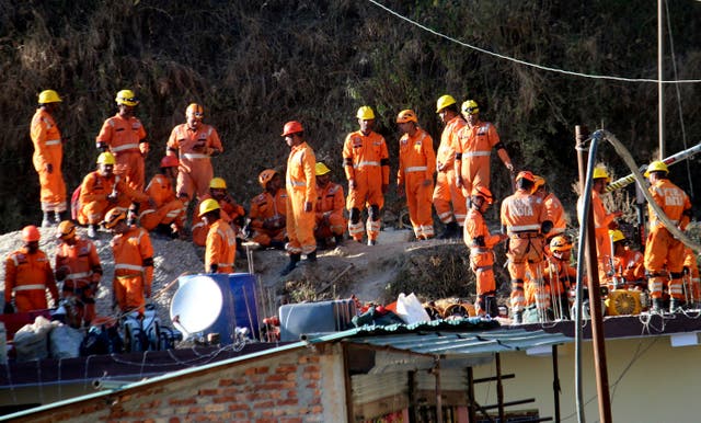 <p>Rescuers rest at the site of an under-construction road tunnel on Friday that collapsed 14 days ago in Silkyara in the northern Indian state of Uttarakhand</p>