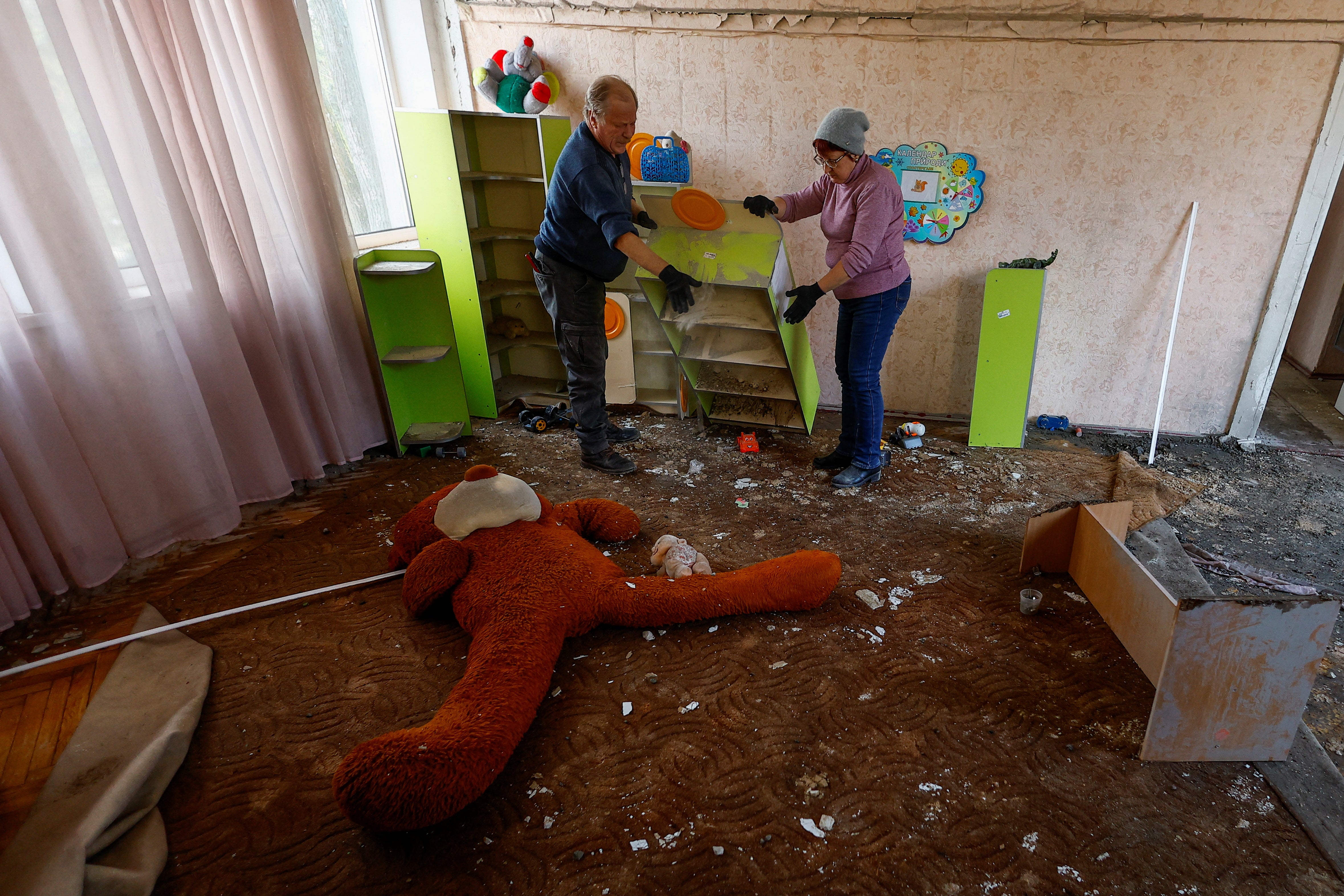 Employees remove debris from a Kyiv kindergarten damaged by Russian drone strikes on Saturday
