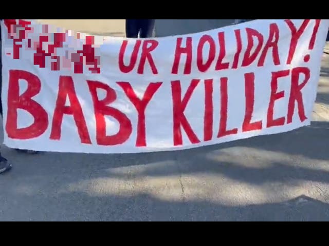 <p>A banner reading ‘F*** ur holiday baby killer’ held outside the Los Angeles home of AIPAC president Michael Tuchin during a protest Thursday</p>
