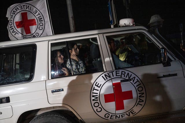 A Red Cross vehicle carrying Israeli hostages drives by at the Gaza Strip crossing into Egypt in Rafah on Saturday (Fatima Shbair/AP)