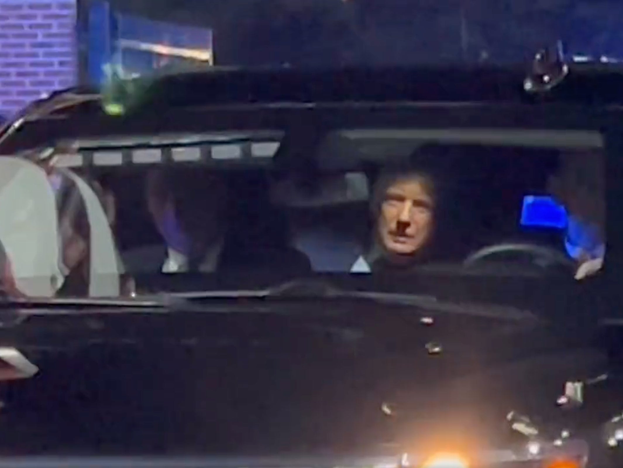 Donald Trump peers out of his vehicle as he is booed by college football fans at Williams-Brice Stadium in South Carolina ahead of the Palmetto Bowl