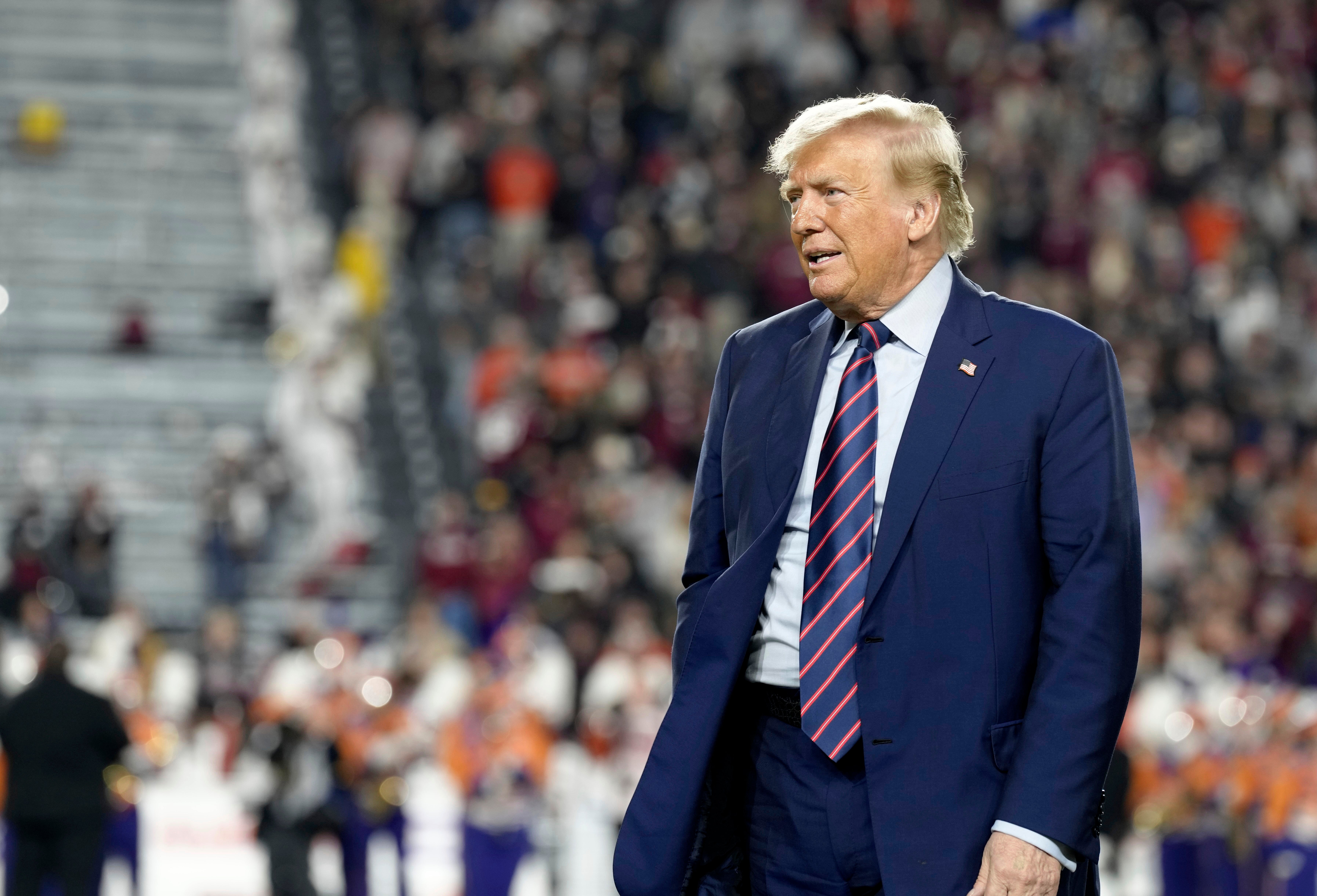Republican presidential candidate and former President Donald Trump stands on the field during halftime in an NCAA college football game between the University of South Carolina and Clemson Saturday, 25 November 2023, in Columbia, South Carolina