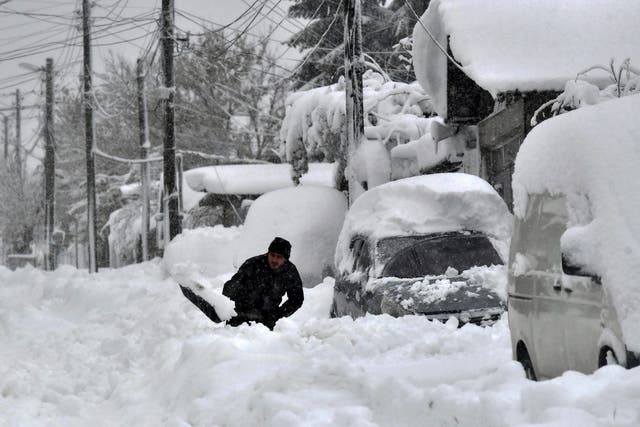 <p>A man shovels snow, as he tries to clear his car in town of Isperih, Northeast Bulgaria</p>
