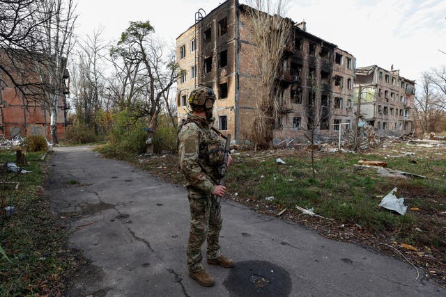 <p>Ukrainian serviceman stands next to residential buildings heavily damaged by permanent Russian military strikes in the frontline town of Avdiivka in Donetsk</p>