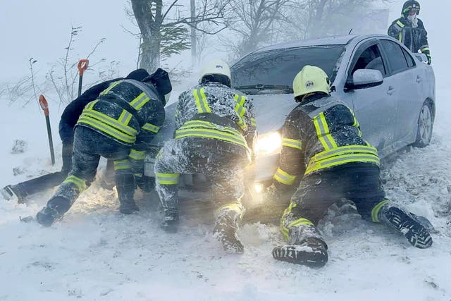 <p>Emergency workers release a car which stuck in snow during a heavy snow storm in Odesa region</p>
