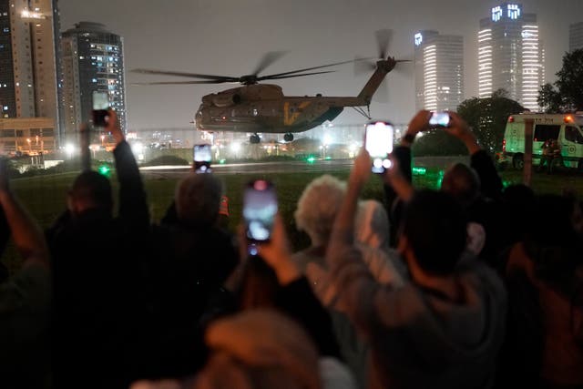 <p>A group of Israelis watch as a helicopter carrying hostages released from the Gaza Strip lands in Israel, Sunday Nov. 26, 2023</p>