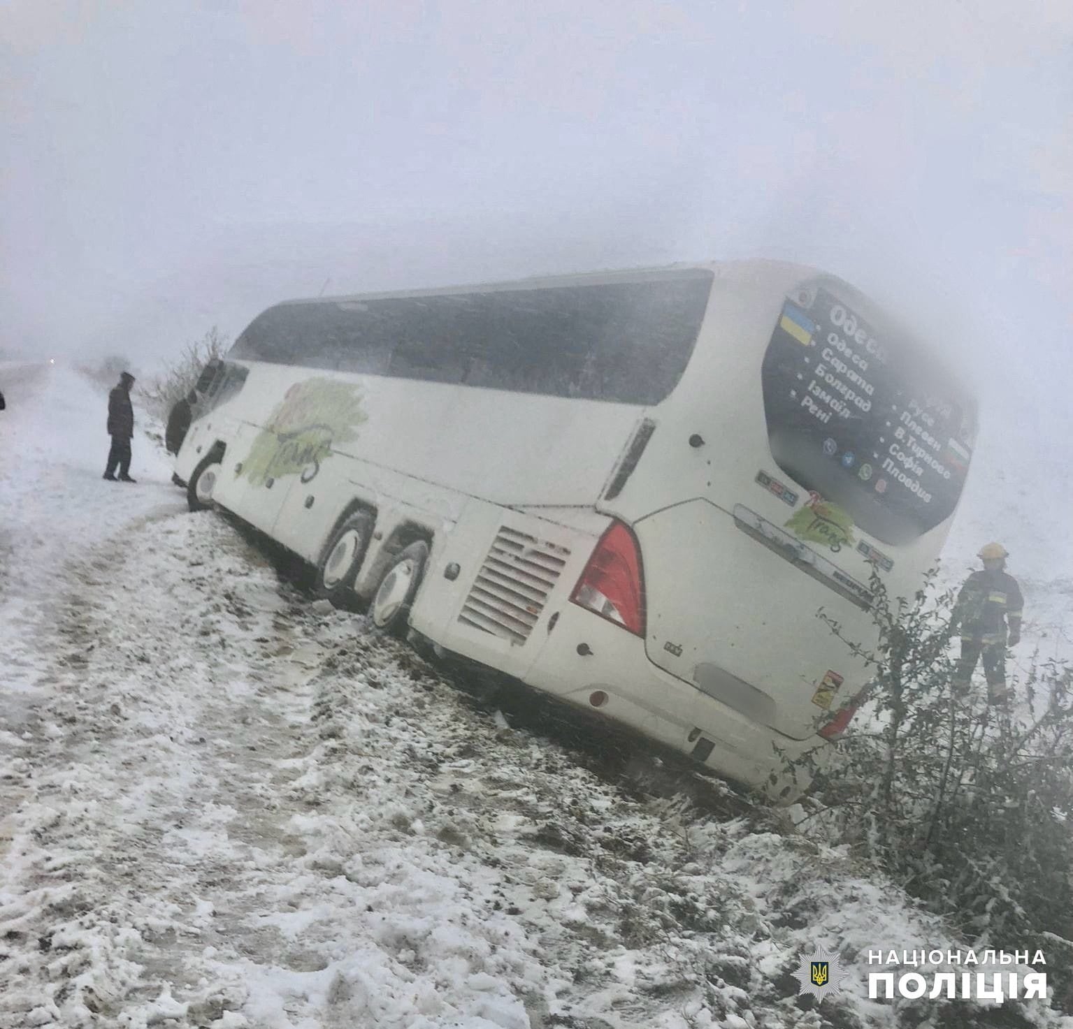Emergency workers release a passenger bus which is stuck outside a road during a heavy snow storm in Odesa region