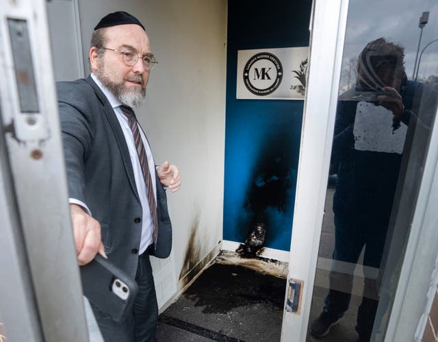 <p>A member of a Jewish community centre shows damage at the entrance Monday, in Montreal</p>