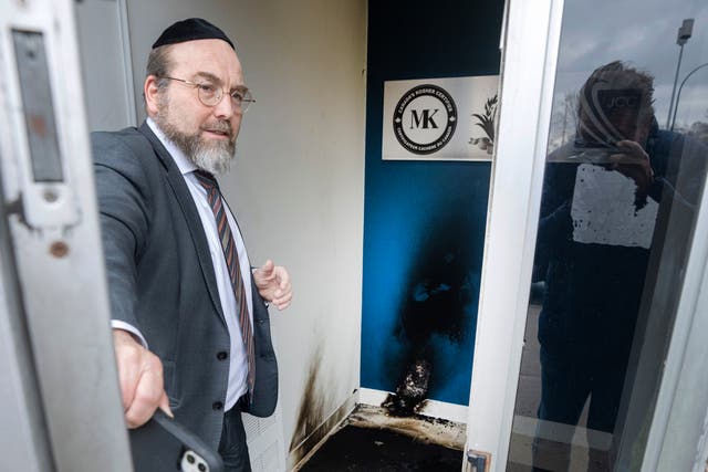 <p>A member of a Jewish community centre shows damage at the entrance Monday, in Montreal</p>